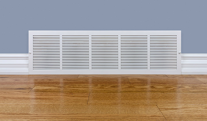 Wall cold/hot air return grille sitting on hardwood floor