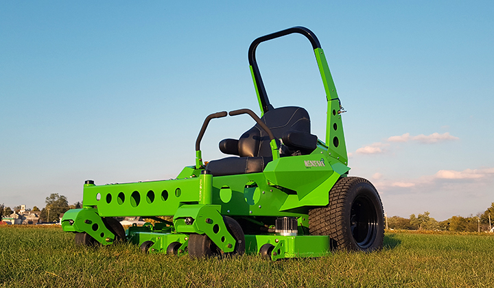 Commercial size mower on green lawn with blue sky in springtime.