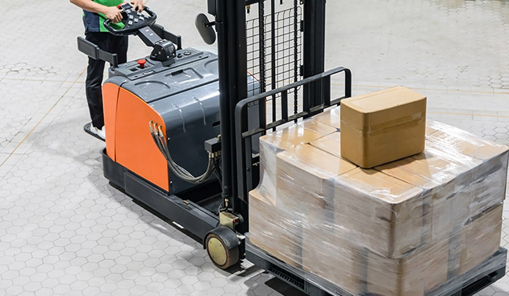 Electrical Forklift truck with boxes on pallet in warehouse.